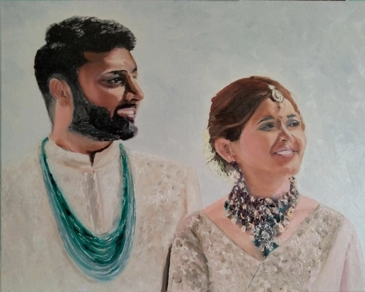 Double profile portrait of an Indian bride and groom, in traditional Indian attire, looking happy.